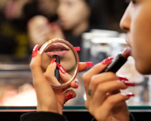 woman applying Santa Ana Semi-Matte Lipstick in mirror