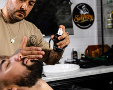 Barber applying Aftershave to a customer.