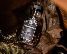 Premium Blends Aftershave Dark Clove 3.3 oz placed on leaves