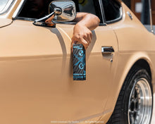 Suavecito X Fast & Furious Premium Blends Aftershave, Quarter Mile Fragrance, held outside car window